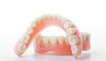 Close up of upper and lower dentures with white background