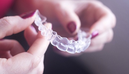 A person holding a clear aligner