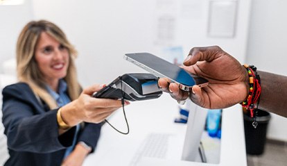 Patient paying for cosmetic dentistry on phone