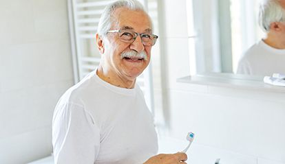 a man brushing his teeth in his bathroom