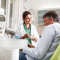 Smiling dentist talking to patient during checkup