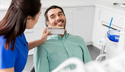 Man smiling at dental assistant using shade scale