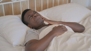 Man struggles to sleep because of a toothache