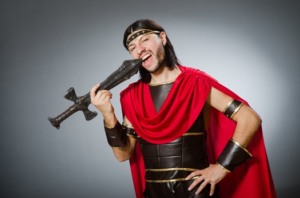 Man in gladiator outfit picks his teeth with a rusty sword